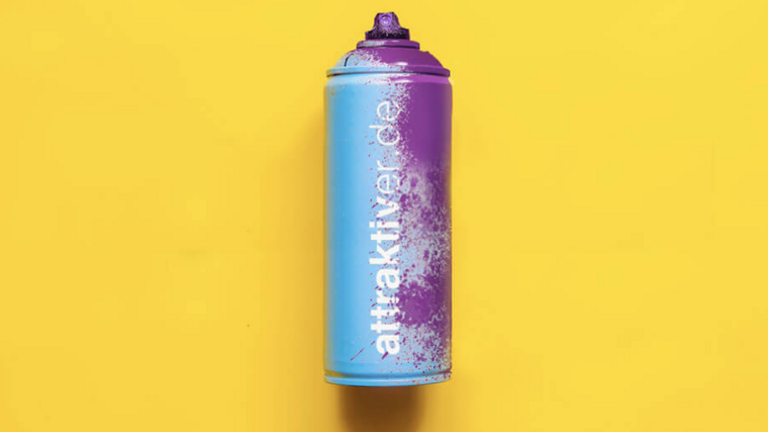 Türkis-violette Spraydose mit der Aufschrift attraktiver.de
