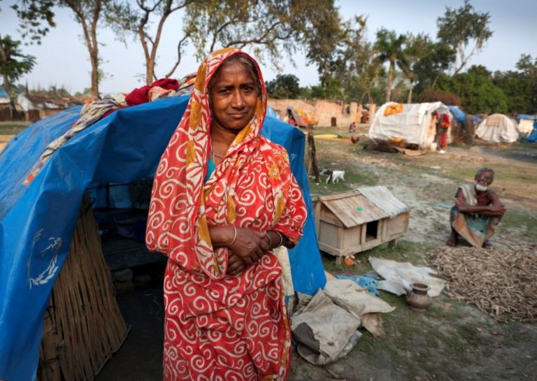 Flüchtlingsfrau im Sari vor blauem Zelt in Bangladesh